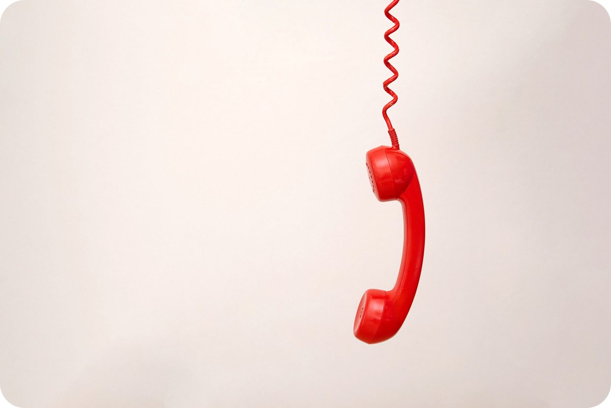 Red vintage telephone handset on cord.